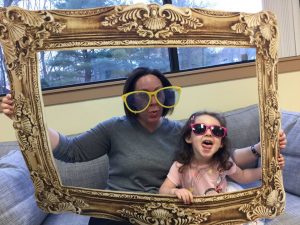 Mom and daughter taking a silly photo together with sunglasses