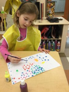 Child at Bright Horizons at the Y painting a picture