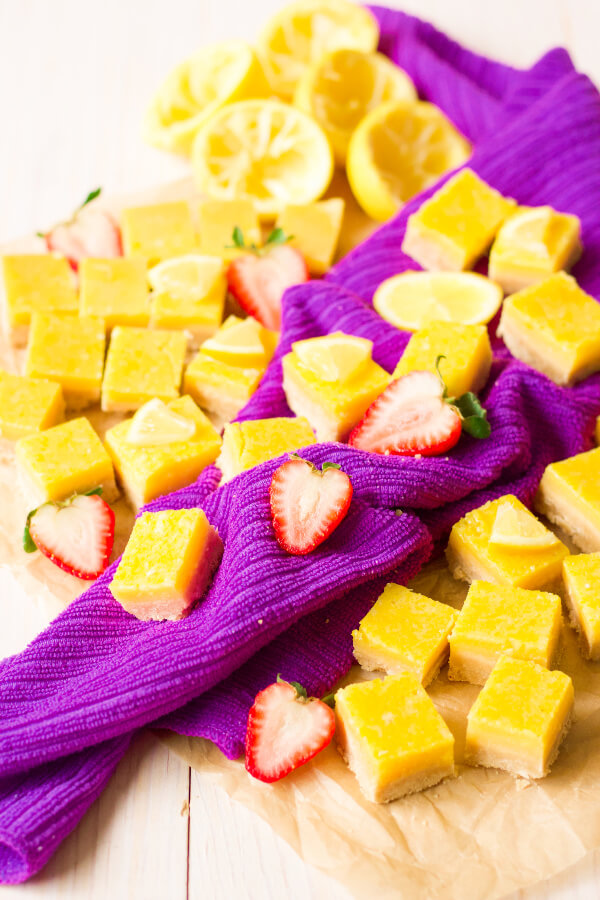 Homemade lemon squares with fresh lemon and strawberries.