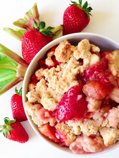 Fresh strawberries and rhubarb and a bowl of cobbler.