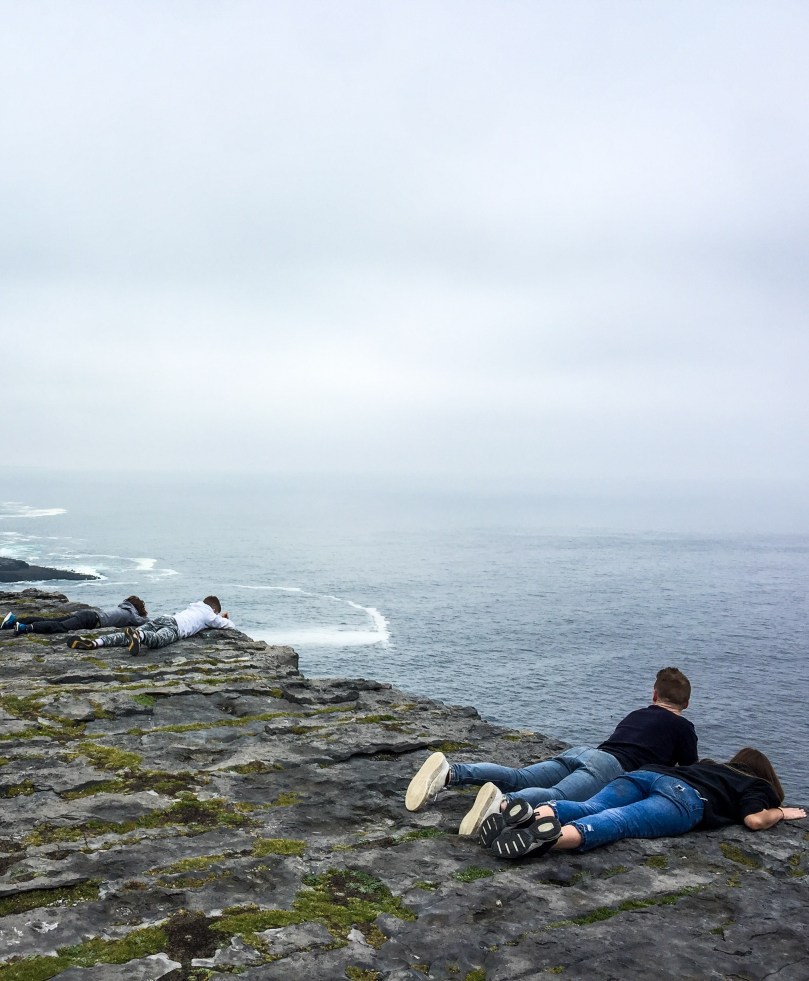 People looking over the edge of a cliff