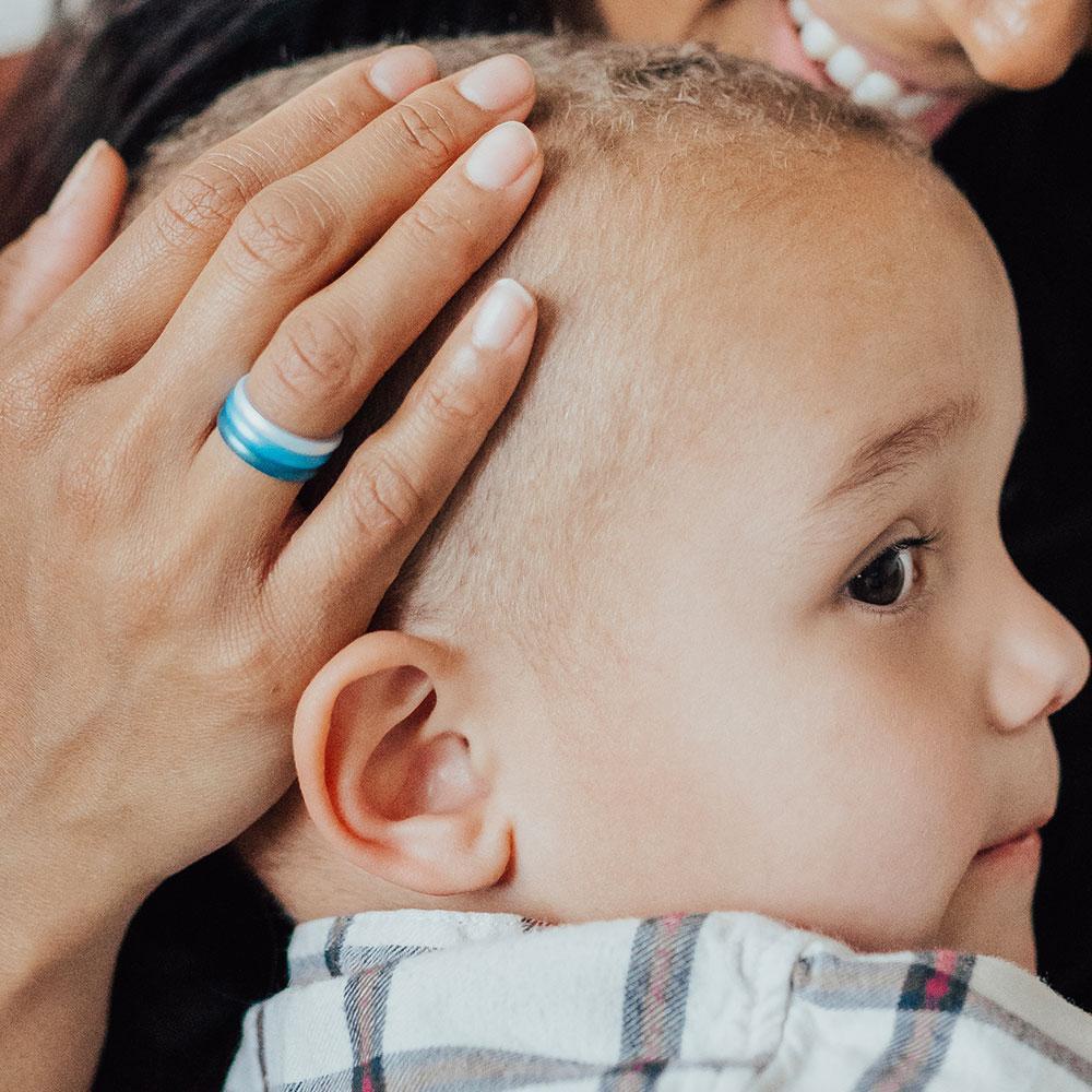mom holding baby's head wearing enso rings - perfect pregnancy friendly jewelry