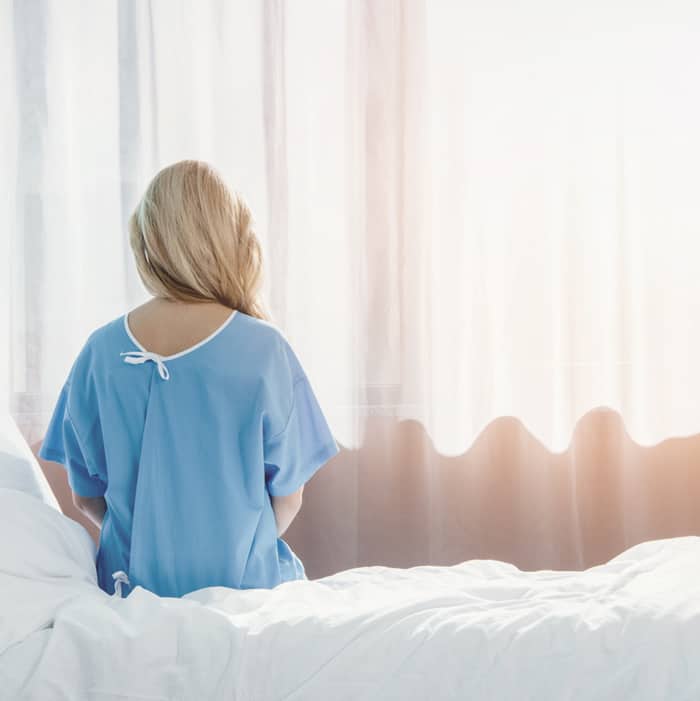 fatal demise delivery - young woman sitting on a hospital bed