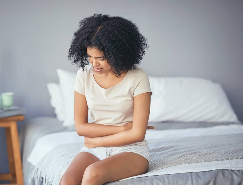 woman clutching abdomen - ectopic pregnancy - what you need to know
