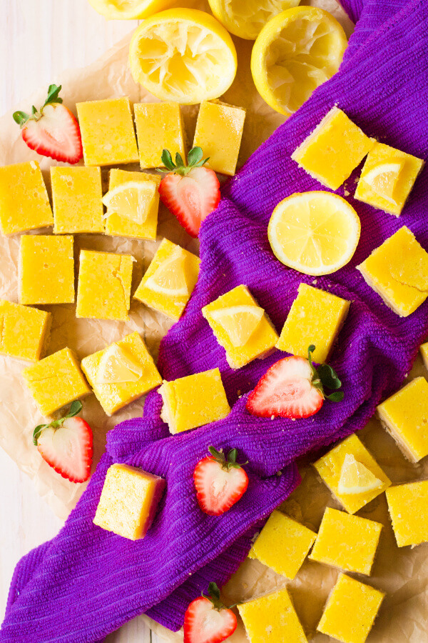 Homemade lemon squares with fresh lemon and strawberries.